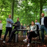 Das Netzhirsch-Team hat sich für ein Gruppenfoto im Wald versammelt.